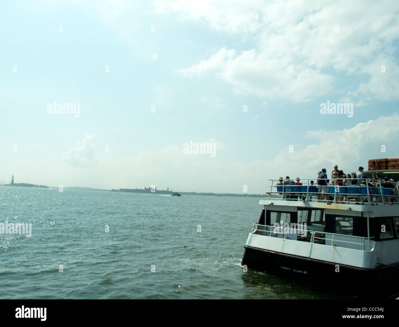 summer ferry ride to governors island, across new york harbor, statue