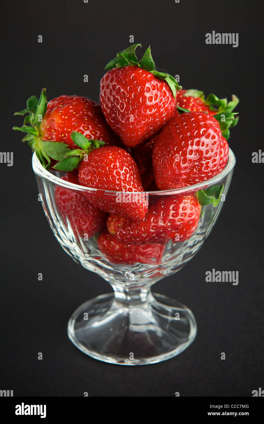 Strawberry in glass container on black background Stock Photo - Alamy