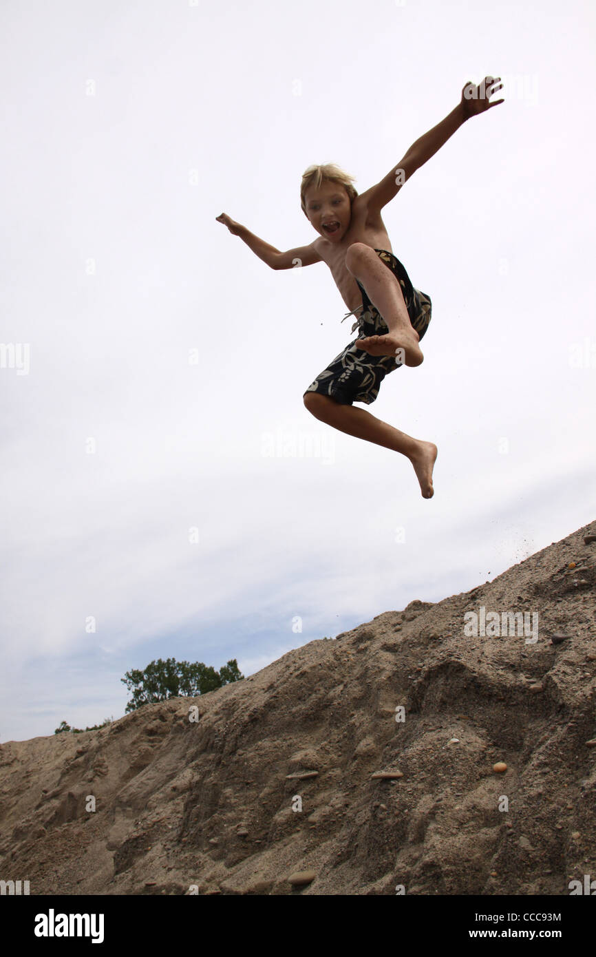 Boy jumping sand dunes Presque Isle State Park Lake Erie Pennsylvania Stock Photo