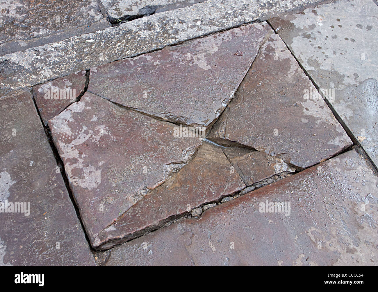 Cracked dangerous paving pavement path health and safety. Broken pavement slab broken paving Stock Photo