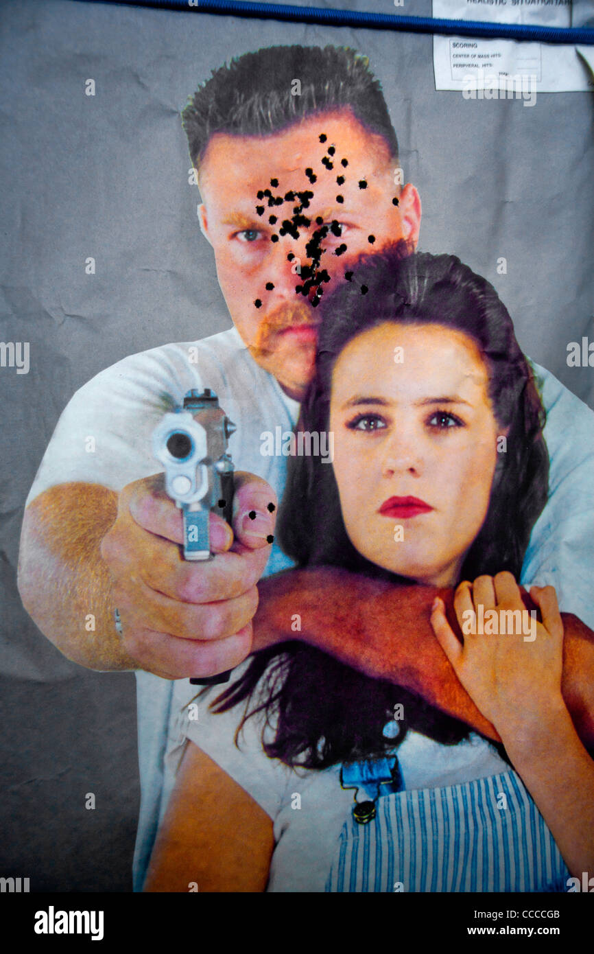 A target of a simulated criminal holding a hostage at a 'Live Fire Kill House' tactical training facility shows bullet pattern. Stock Photo