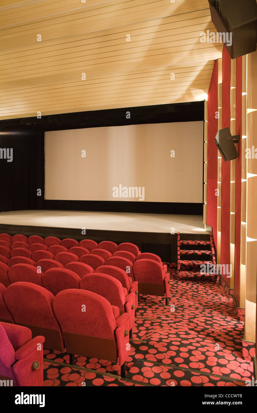 Empty cinema auditorium with line of chairs and projection screen ...