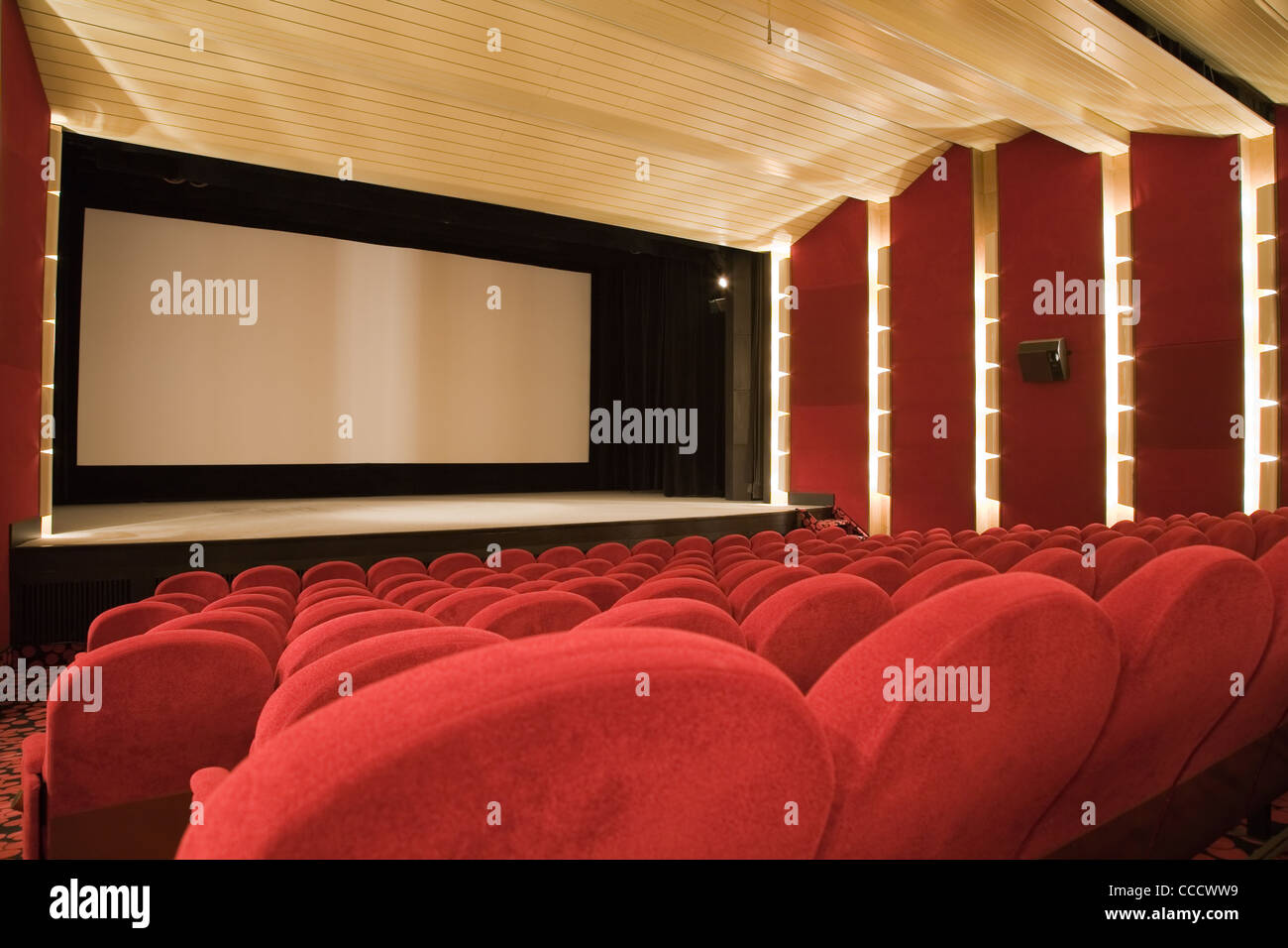 Empty cinema auditorium with line of chairs and projection screen ...