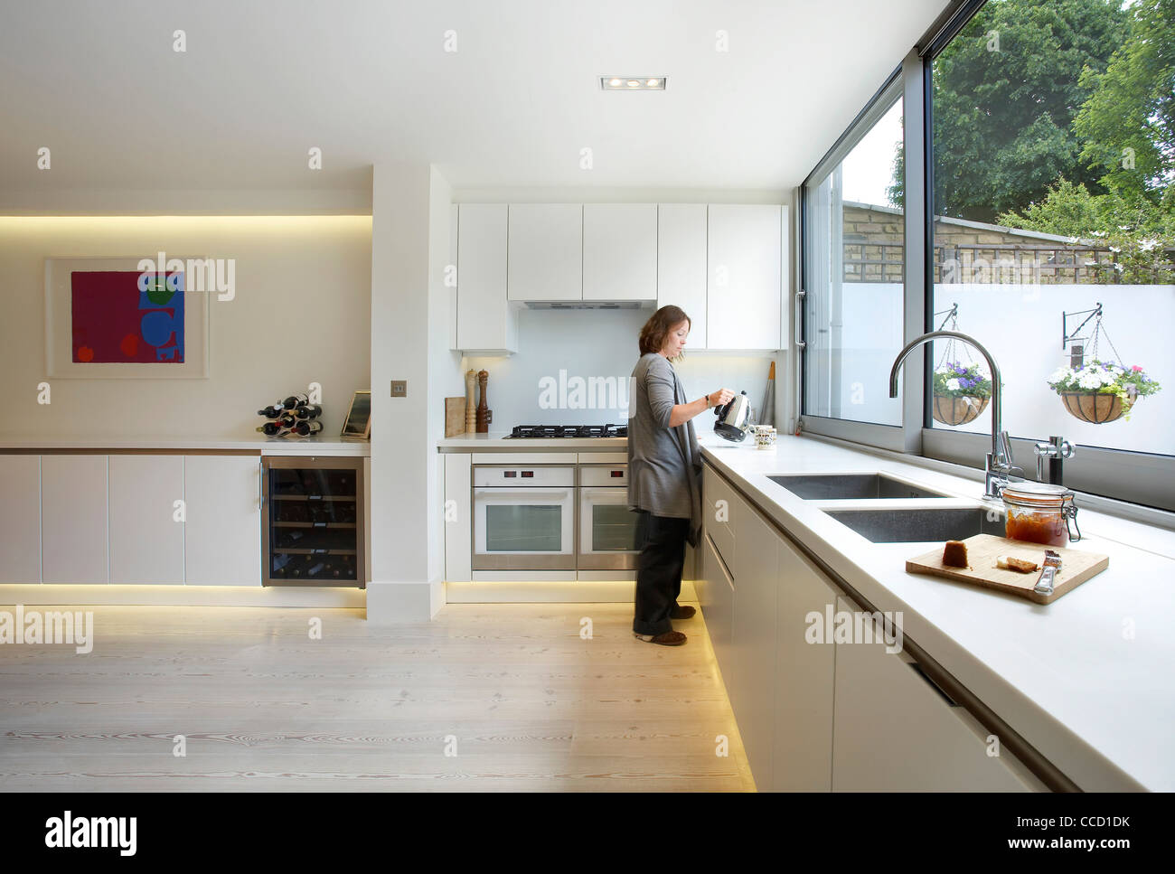 PRIVATE HOUSE, BUCKLEY GRAY YEOMAN, LONDON, 2010, WOMAN IN LARGE KITCHEN Stock Photo