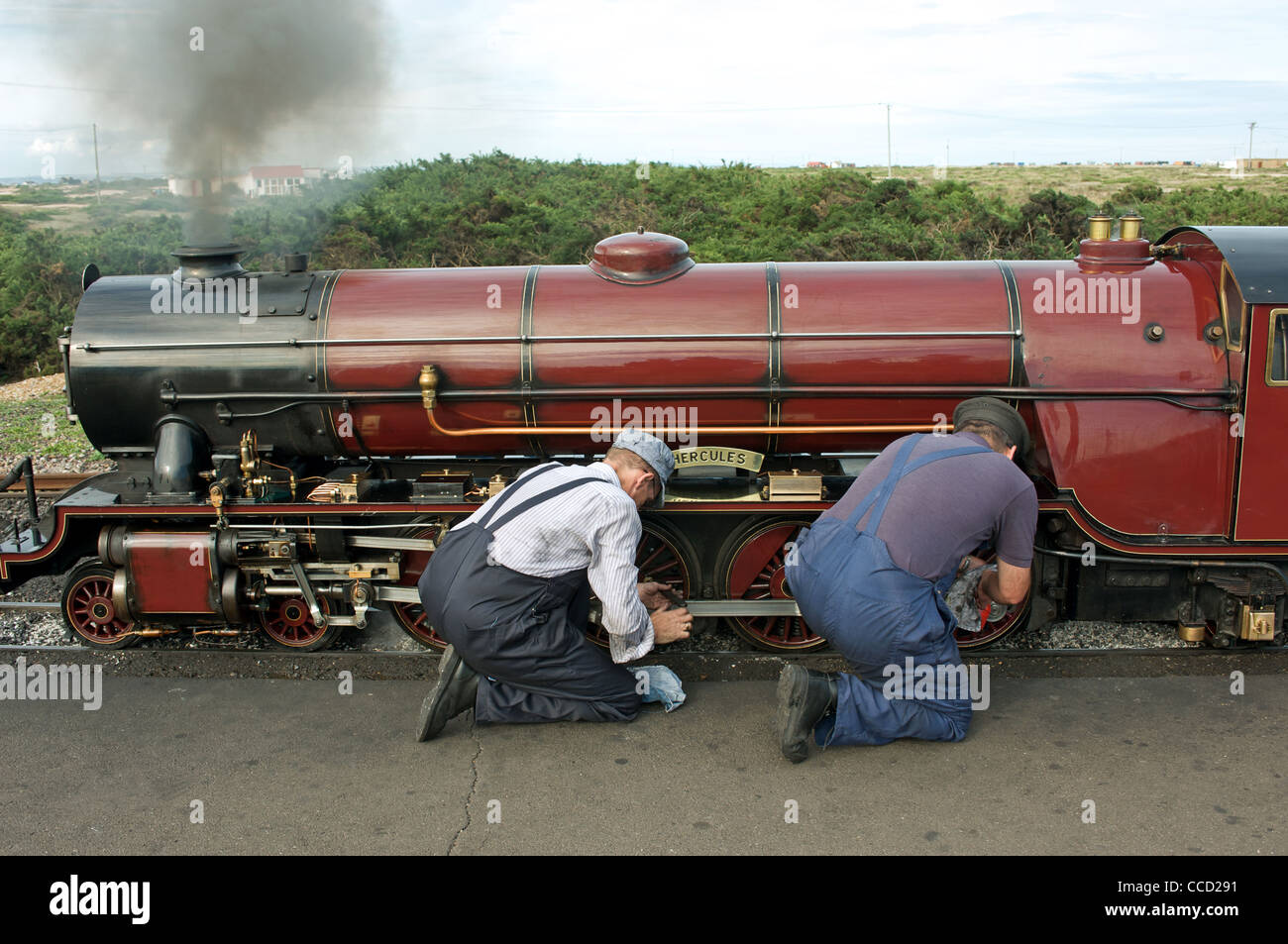 Driver and fireman making adjustments to a narrow gauge steam engine Stock Photo