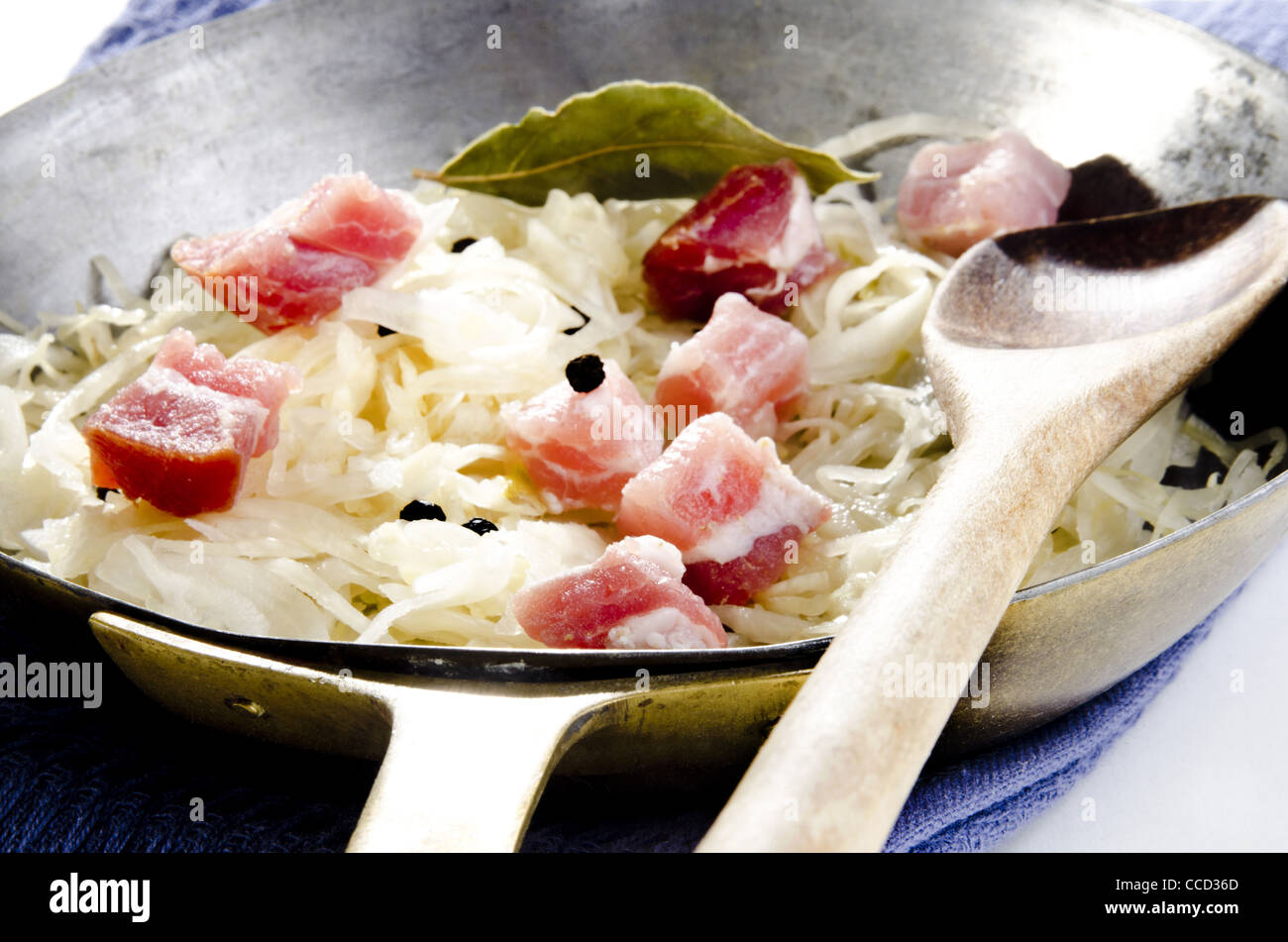 Sauerkraut with diced bacon and bay leaf in a pan Stock Photo