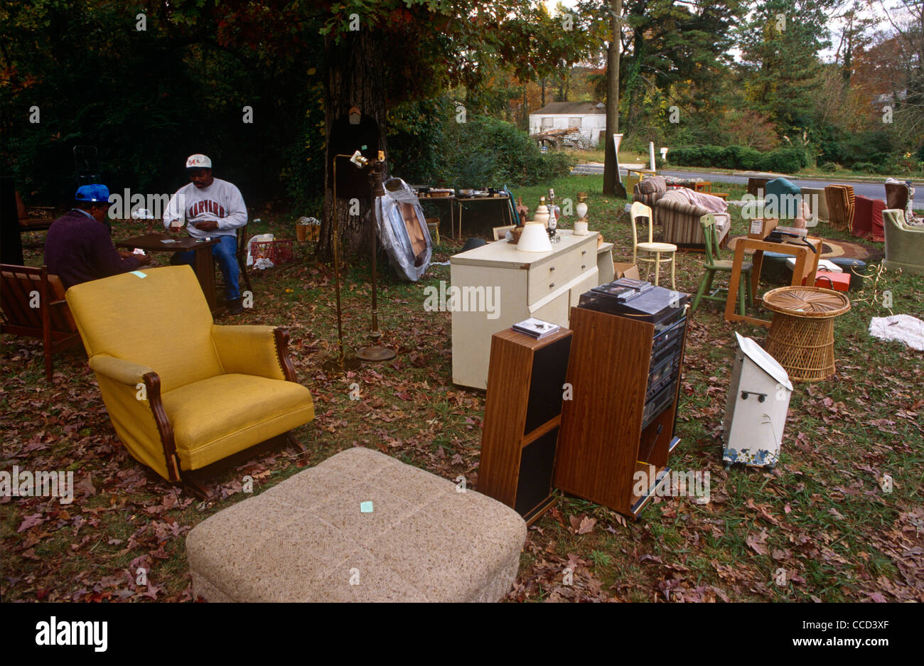 Two Georgian men play cards while waiting for passing trade during an outdoor yard sale in an Atlanta suburb. Stock Photo