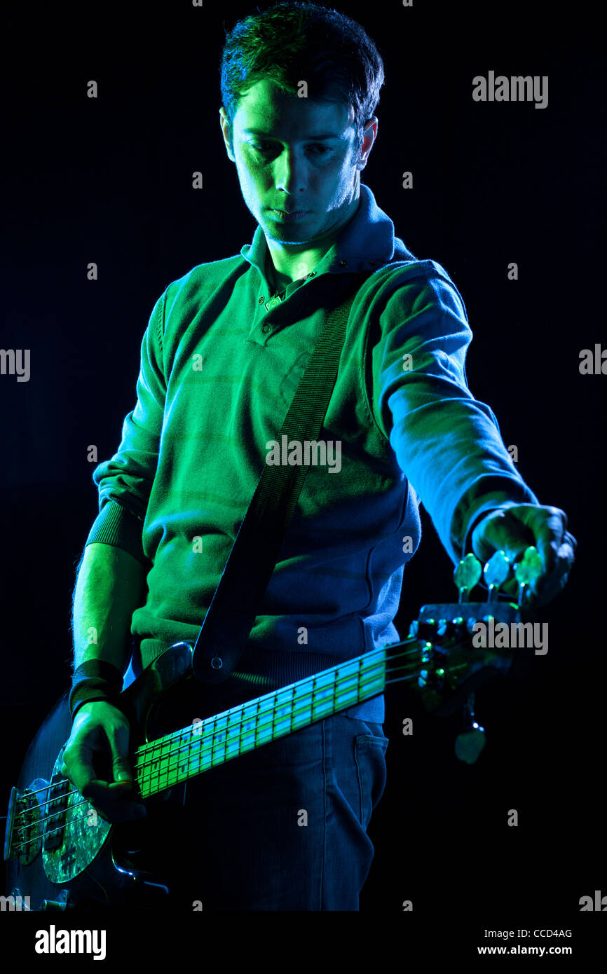 Bassist Tuning His Bass During a Concert Stock Photo