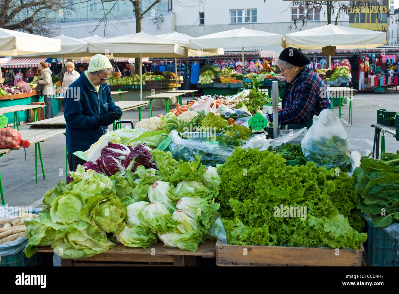 A woman buying vegetables from market stall in Ljubljana, Slovenia. Stock Photo