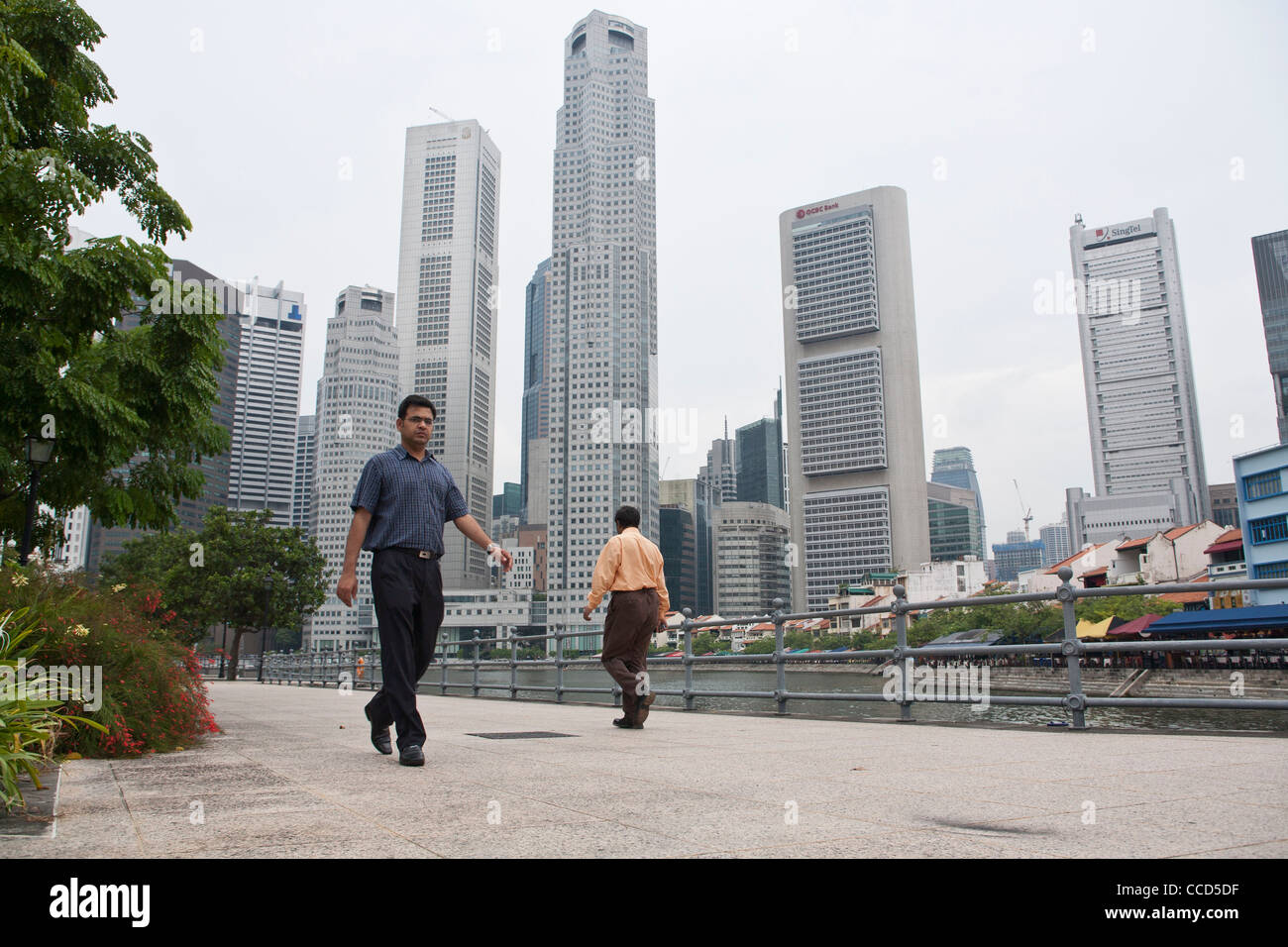 People walk past the central business district of Singapore Stock Photo