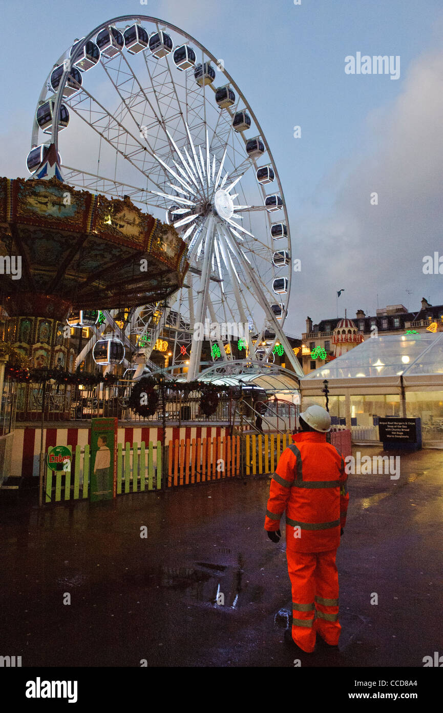 The big wheel in George Square Glasgow - closed because of high winds on the 8th December 2012 and guarded by a security person Stock Photo