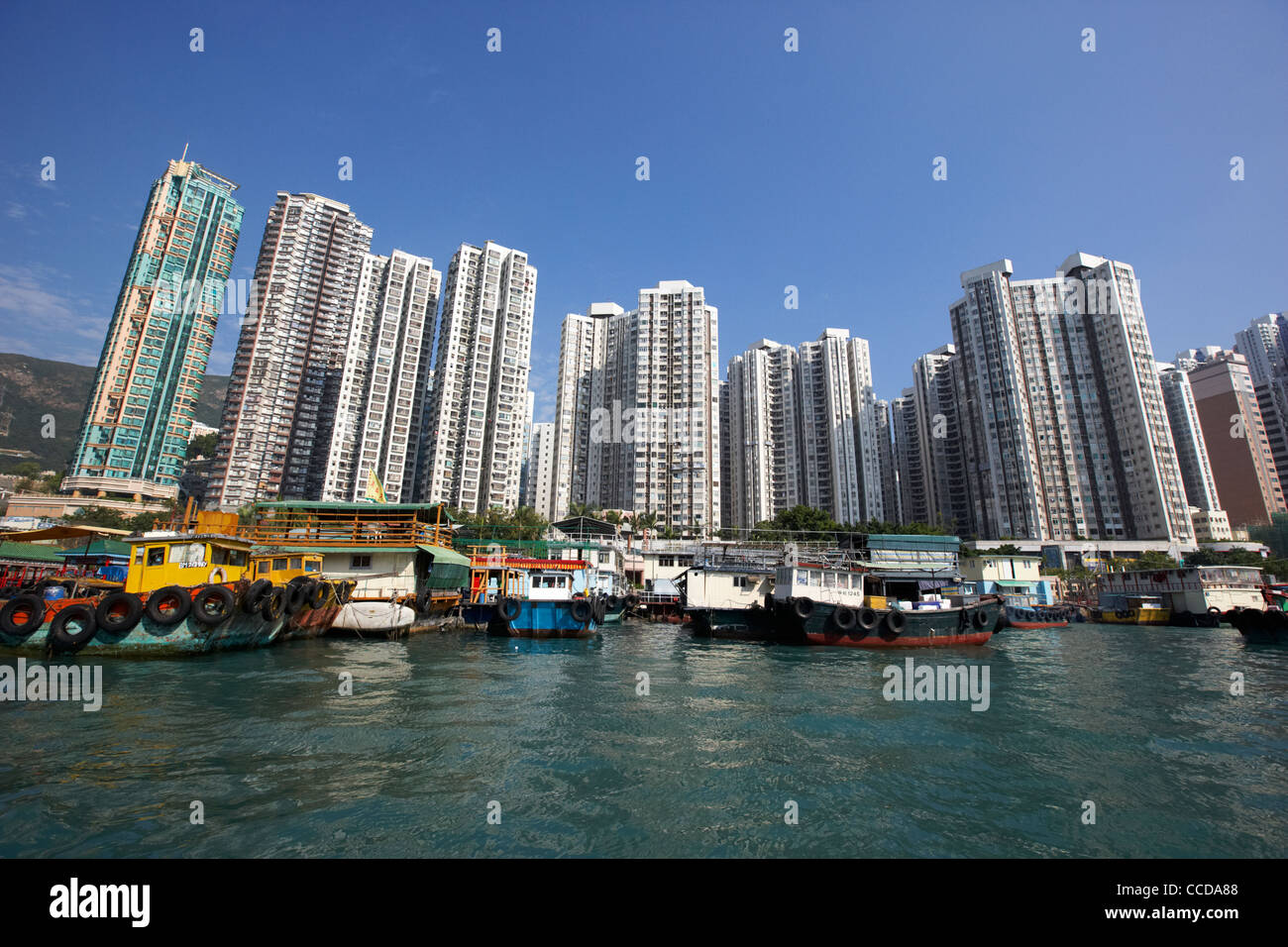 fishing boats and houseboats in aberdeen harbour in front of apartment blocks hong kong hksar china asia Stock Photo