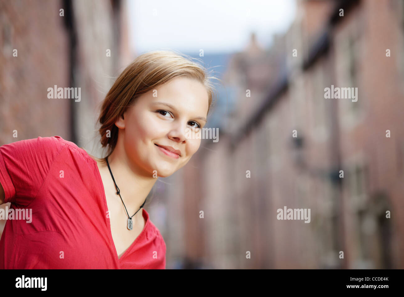 Happy young woman photographed in a city street Stock Photo