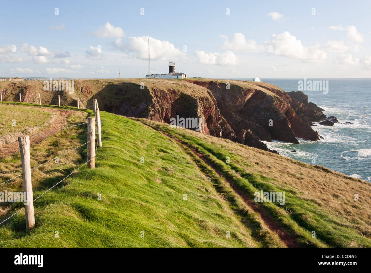 Scenic view of a cliff with lighthouse in the background in St Bride's Bay, southwest coast of Wales. Stock Photo