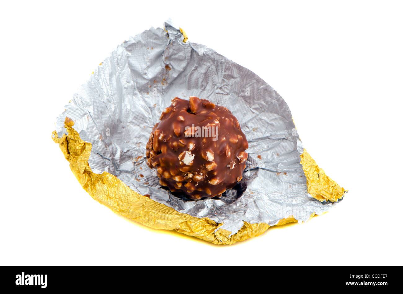 Candy coated with chocolate and nuts rolled out of golden paper