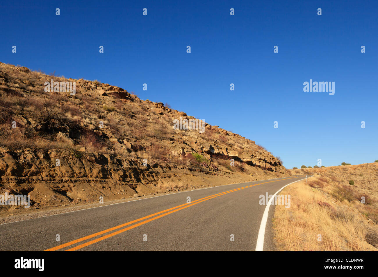 A rural highway in rugged New Mexico landscape. Stock Photo
