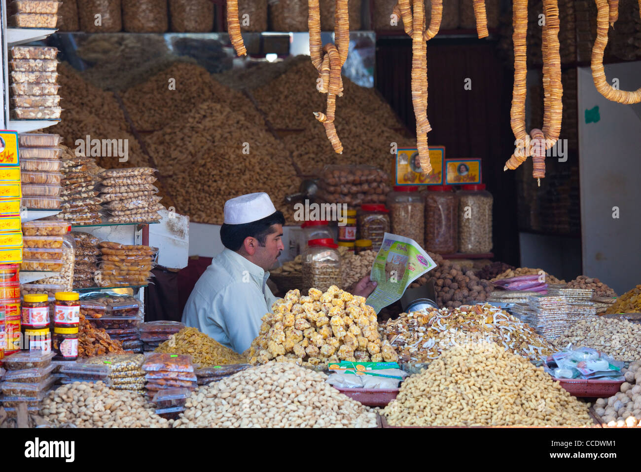 Vendor reading a newspaper at a snack shop, Murree, Punjab Province, Pakistan Stock Photo