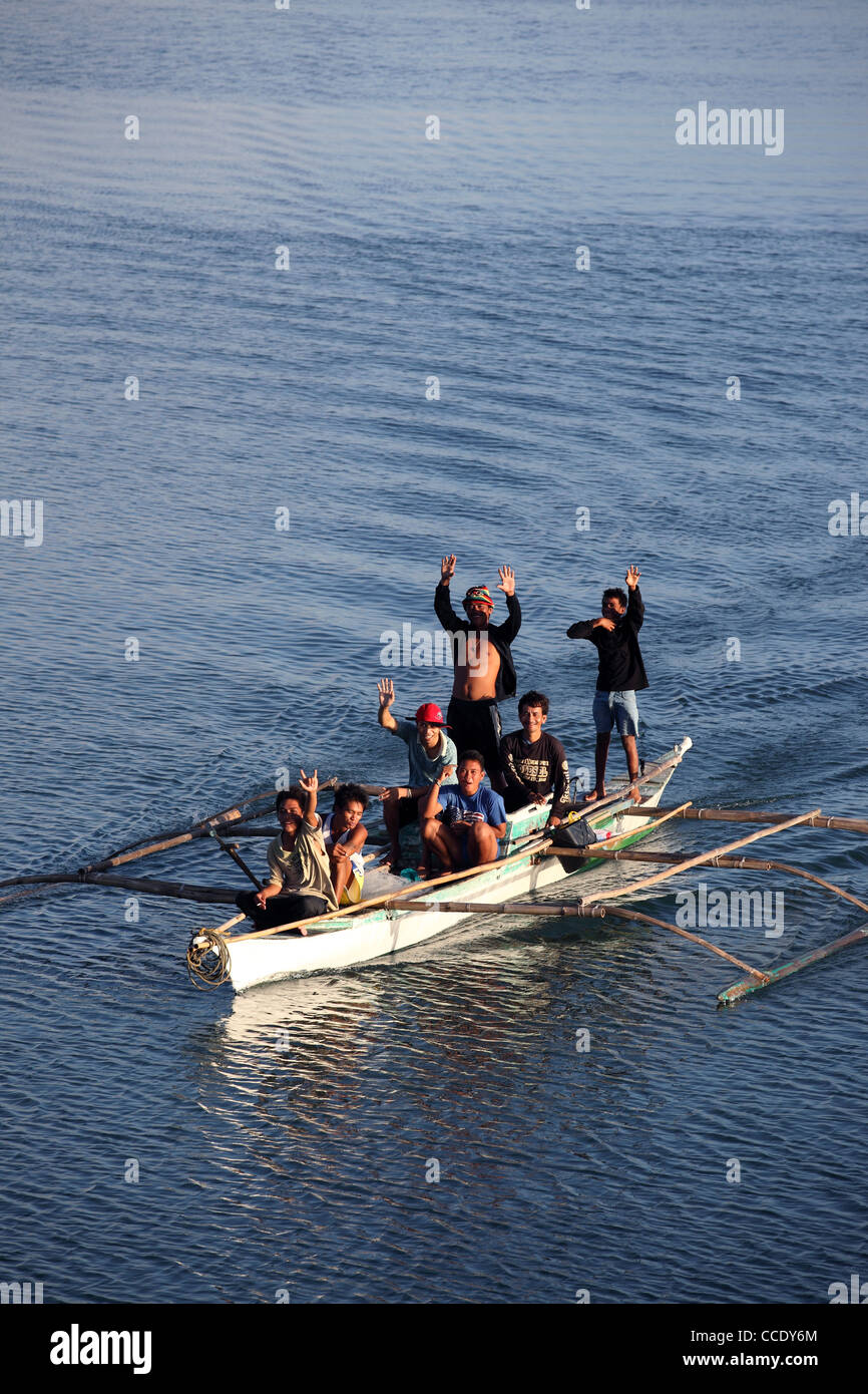 Happy group of Philippine men in outrigger canoe off Bohol Island. Tagbiliran, Bohol, Central Visayas, Philippines Stock Photo