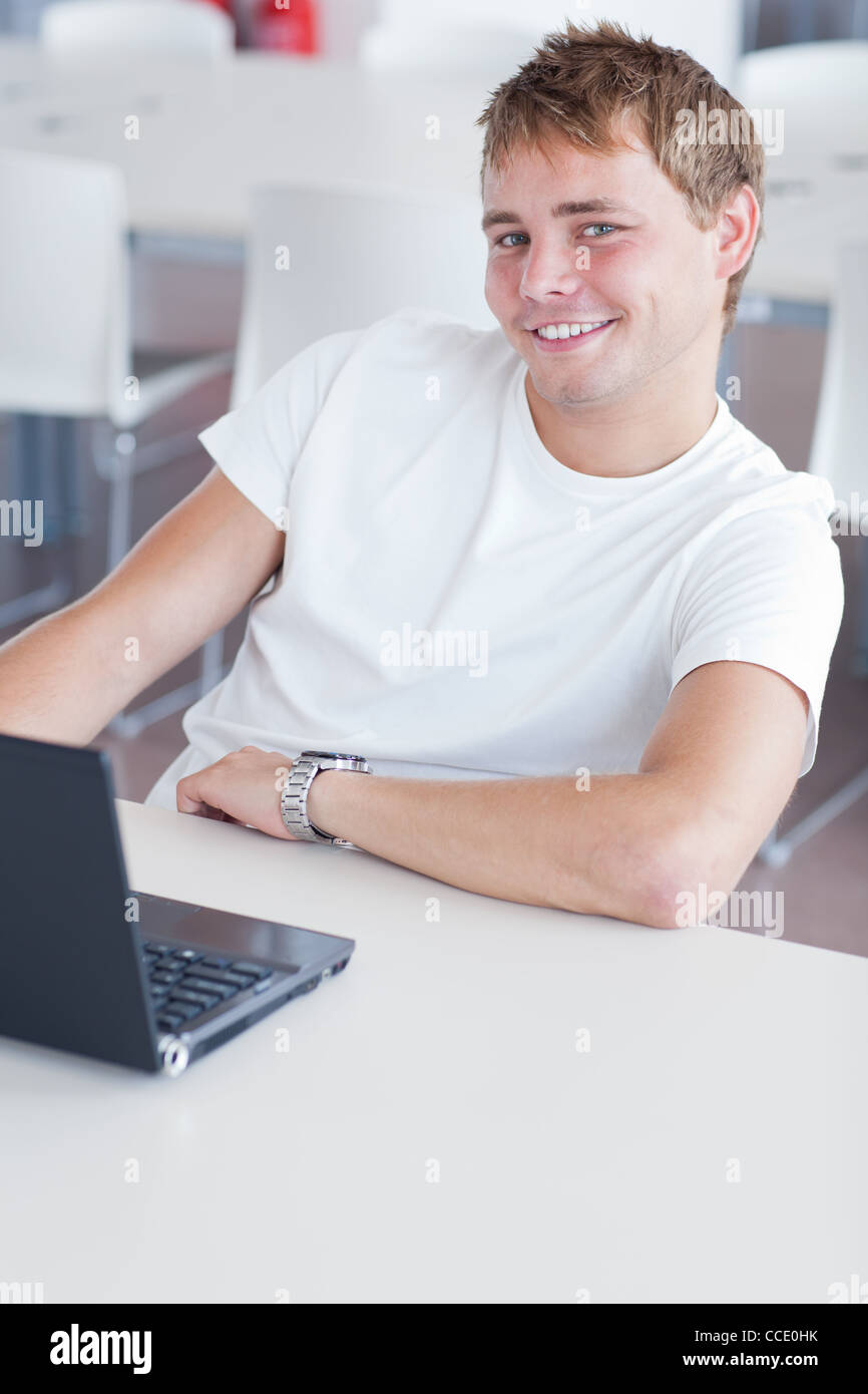 handsome college student with laptop computer in university library ...