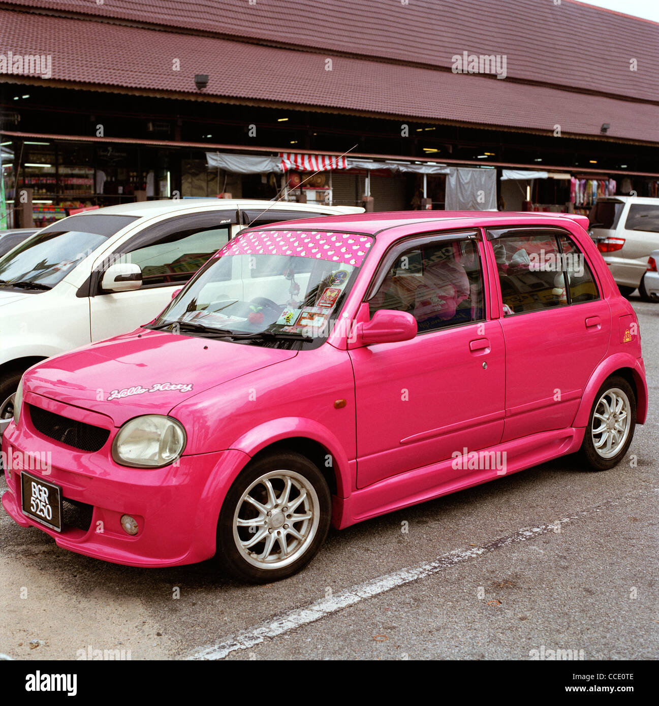 Pink car individuality in Melaka in Malaysia in Far East Southeast Asia. Vivid Colour Colourful Cars Urban Feminine Travel Stock Photo
