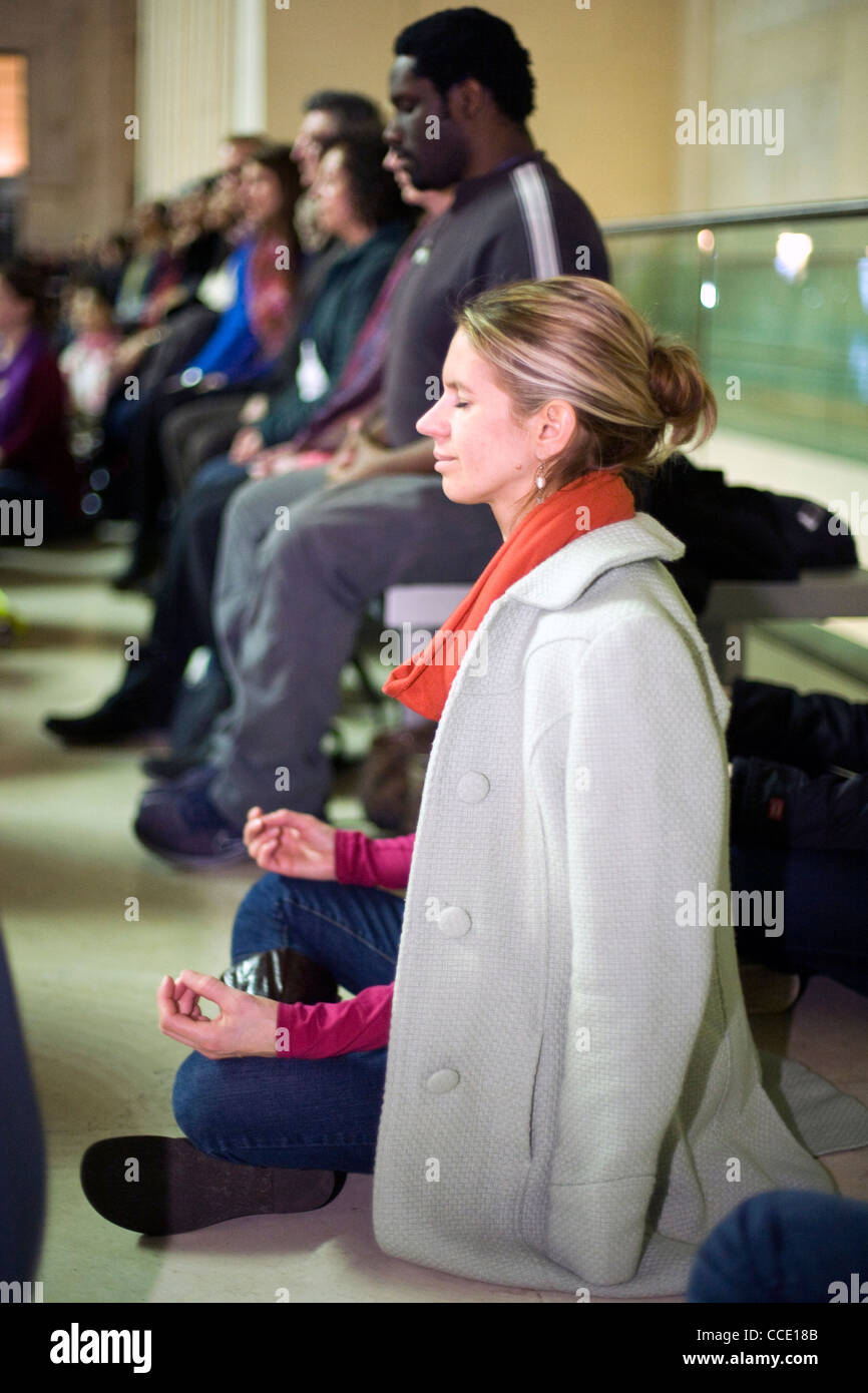 A woman silently meditates as part of a meditation flash mob in the Great Court of the British Museum Stock Photo