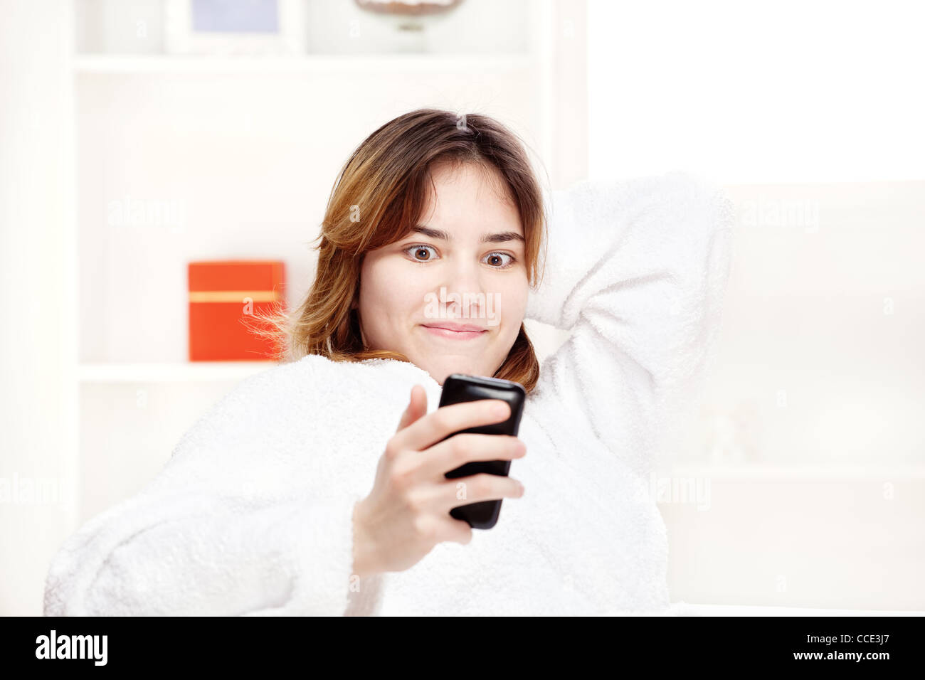 teenager girl at home surprised looking at cell phone Stock Photo - Alamy