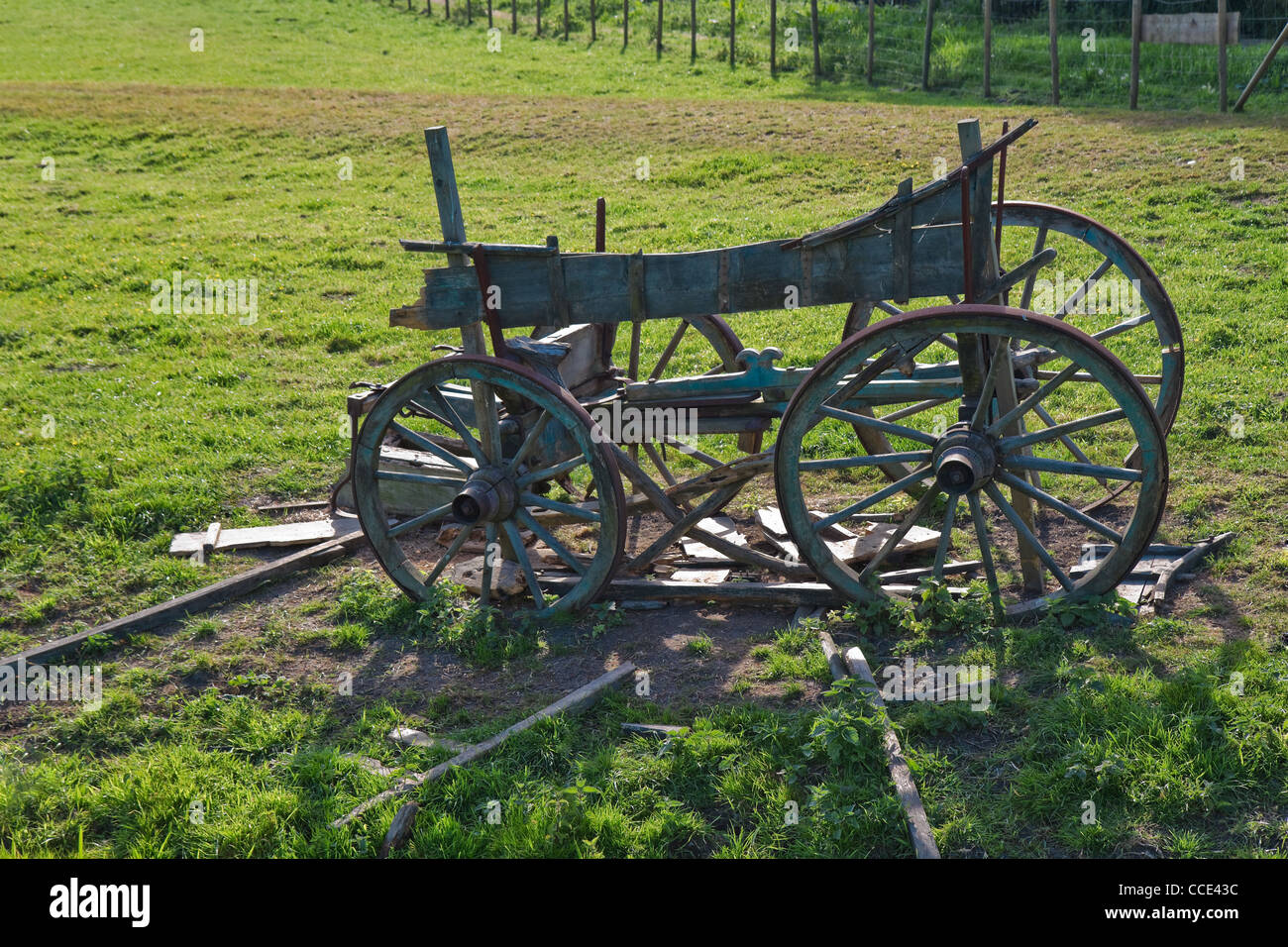 Old four wheel wooden horse cart on a field slowly falling to pieces Stock Photo