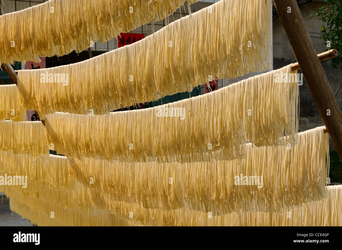 Noodles hanging outside in the sun to dry on rods in Fuli near Yangshuo China Stock Photo
