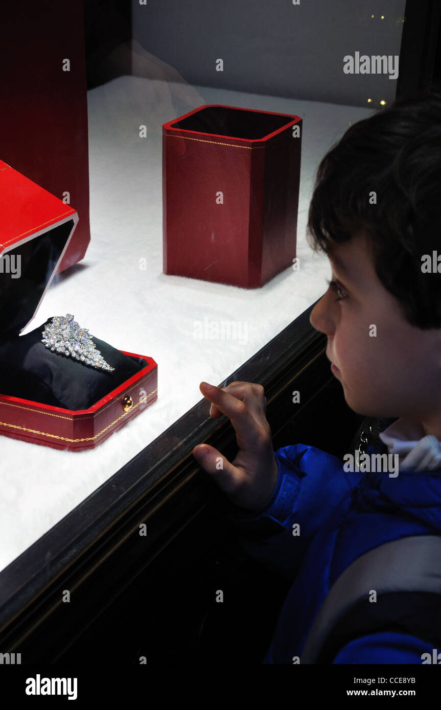 Cartier store window display with diamond jewelry and child watching, Fifth Avenue, New York, USA Stock Photo