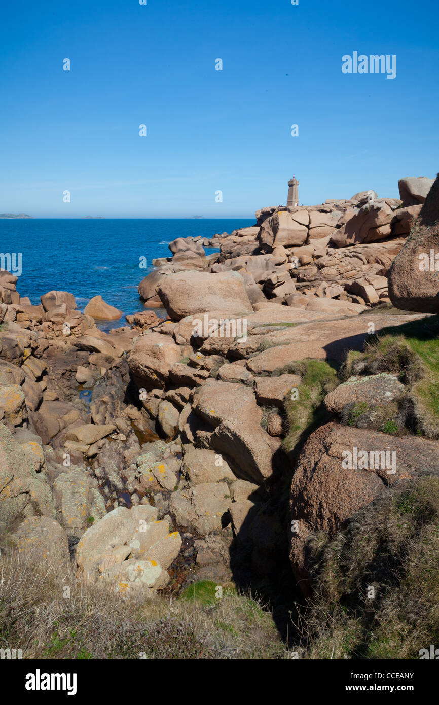 Lighthouse By Rocks View along the rocks towards a stone lighthouse Stock Photo - Alamy