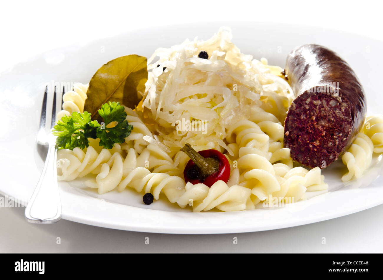 Sauerkraut with noodle and home made sausage on a white plate Stock Photo