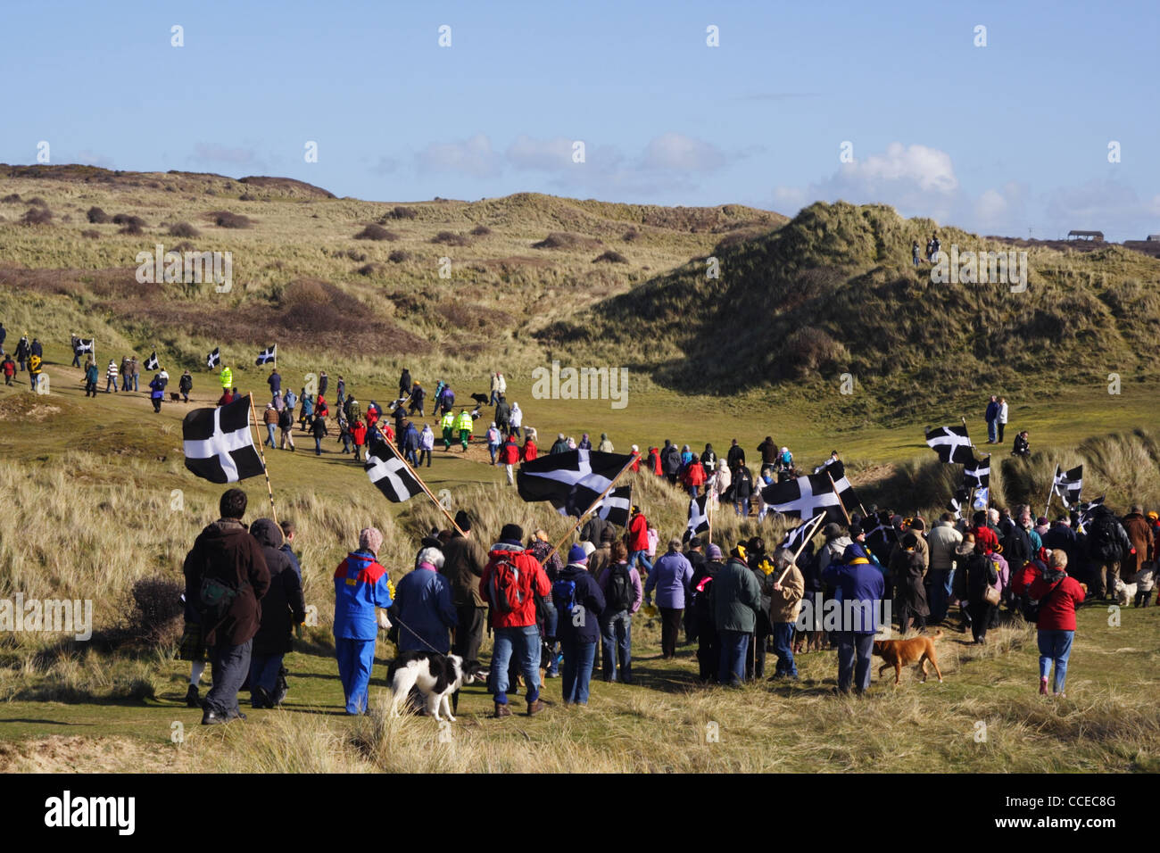 Cornish marchers cross the dunes at Perranporth to celebrate St Piran. Stock Photo