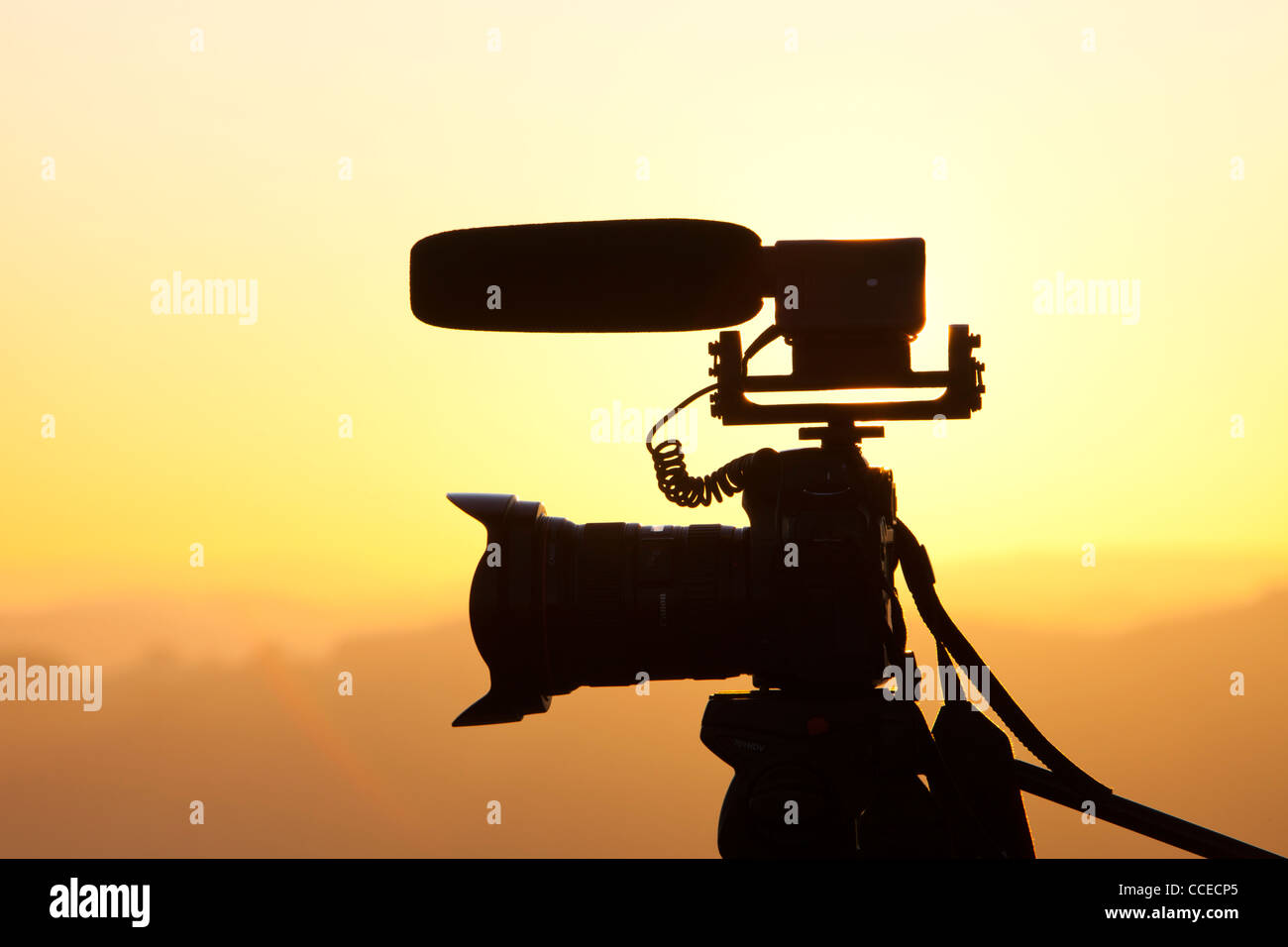 A DSLR camera on a tripod with video microphone on a tripod at sunset above Windermere, Lake District, UK. Stock Photo