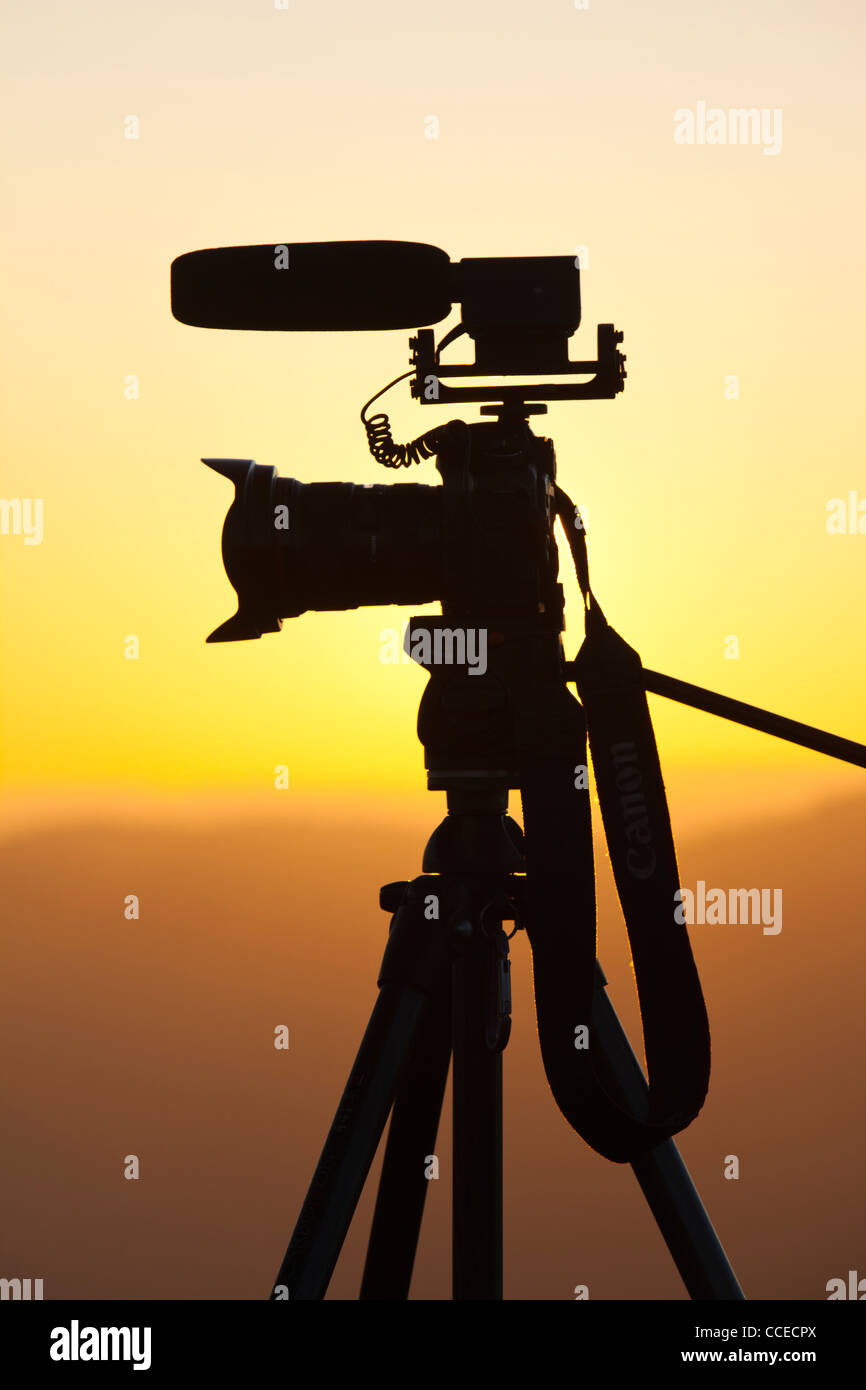 A DSLR camera on a tripod with video microphone on a tripod at sunset above Windermere, Lake District, UK. Stock Photo
