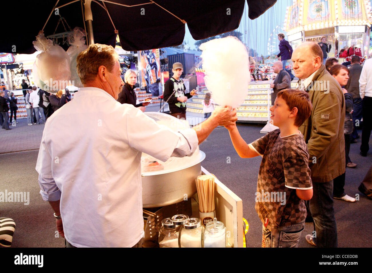 boy infront of german mobile sales booth at fair buying cotton candy, germany, europe Stock
