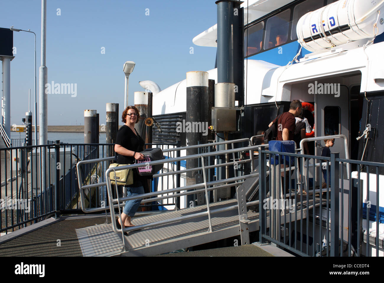 Vacationers steps on the boat to the island of Terschelling in the North-Netherlands Stock Photo