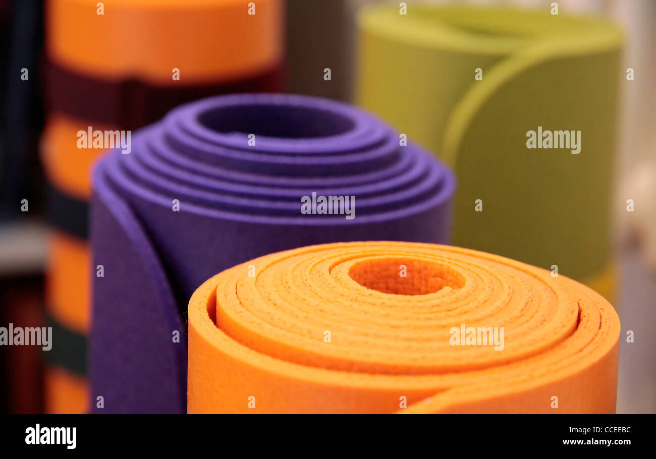 Colorful yoga mats rolled up in a yoga school Stock Photo