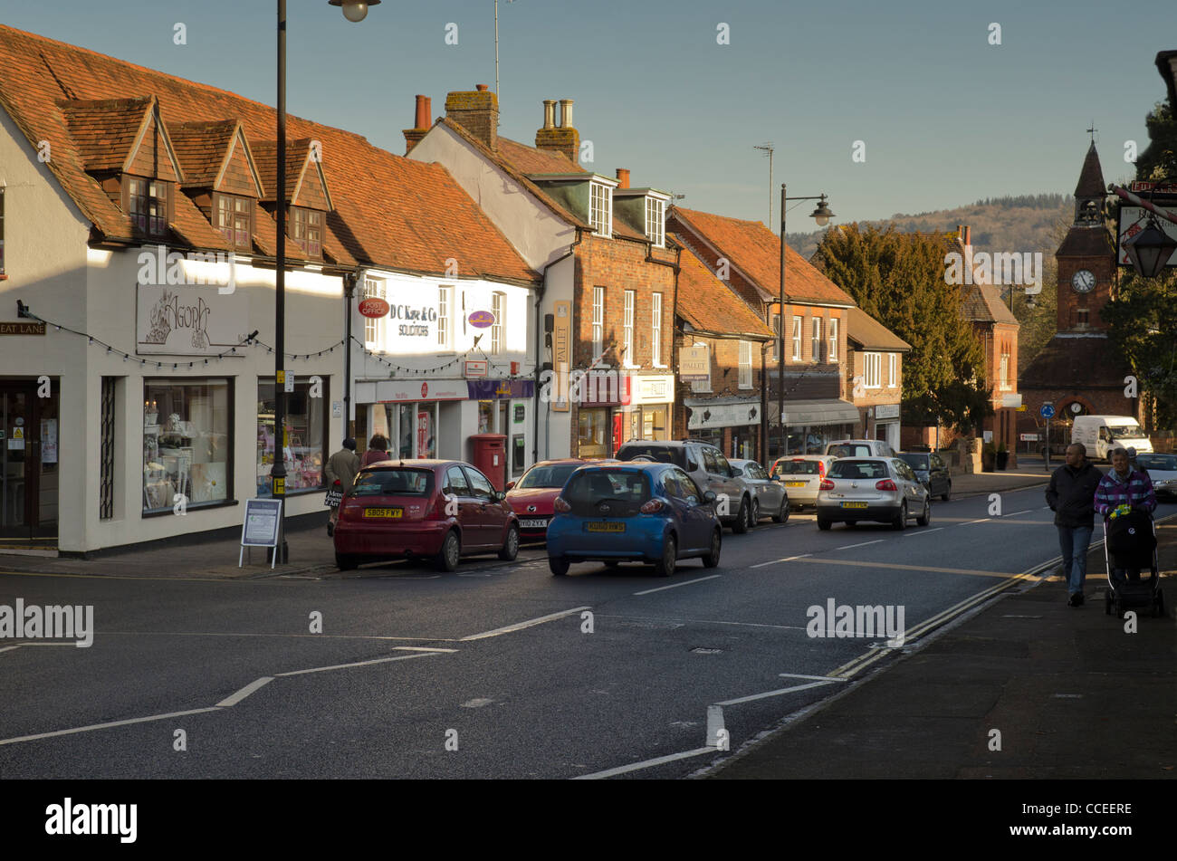 pedestrians passing cars, traffic, small shops and businesses in High Street Wendover Bucks UK Stock Photo