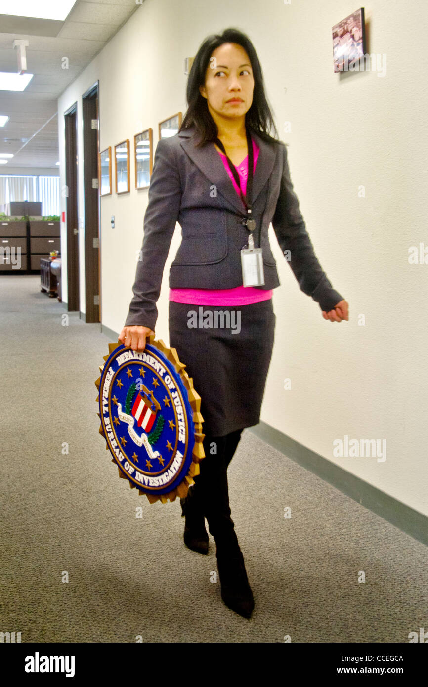 A Filipino-American FBI agent carries a bureau logo in the Santa Ana, CA, office. MODEL RELEASE Stock Photo