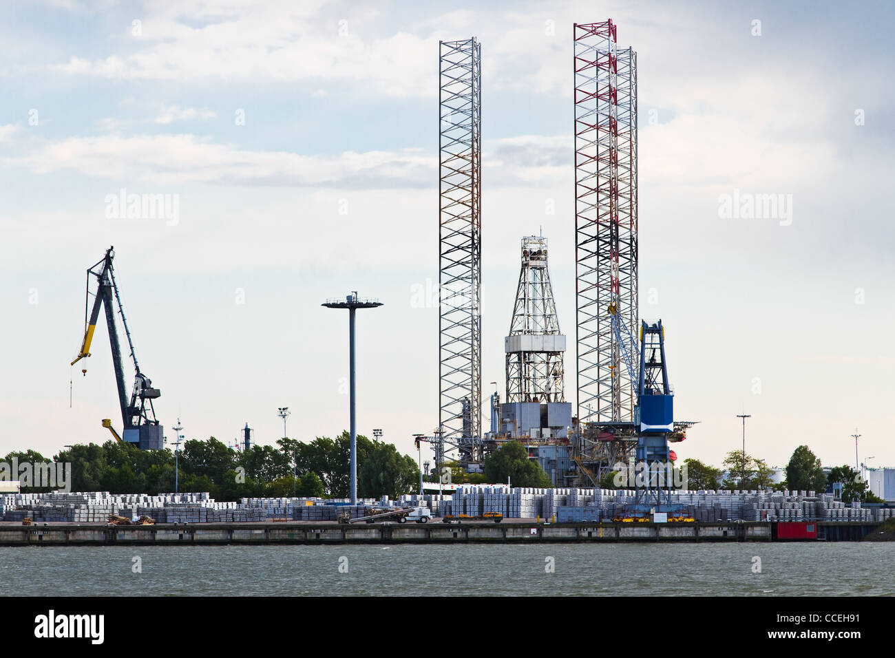 Industrial cranes and drilling platform in dock at the riverside Stock Photo