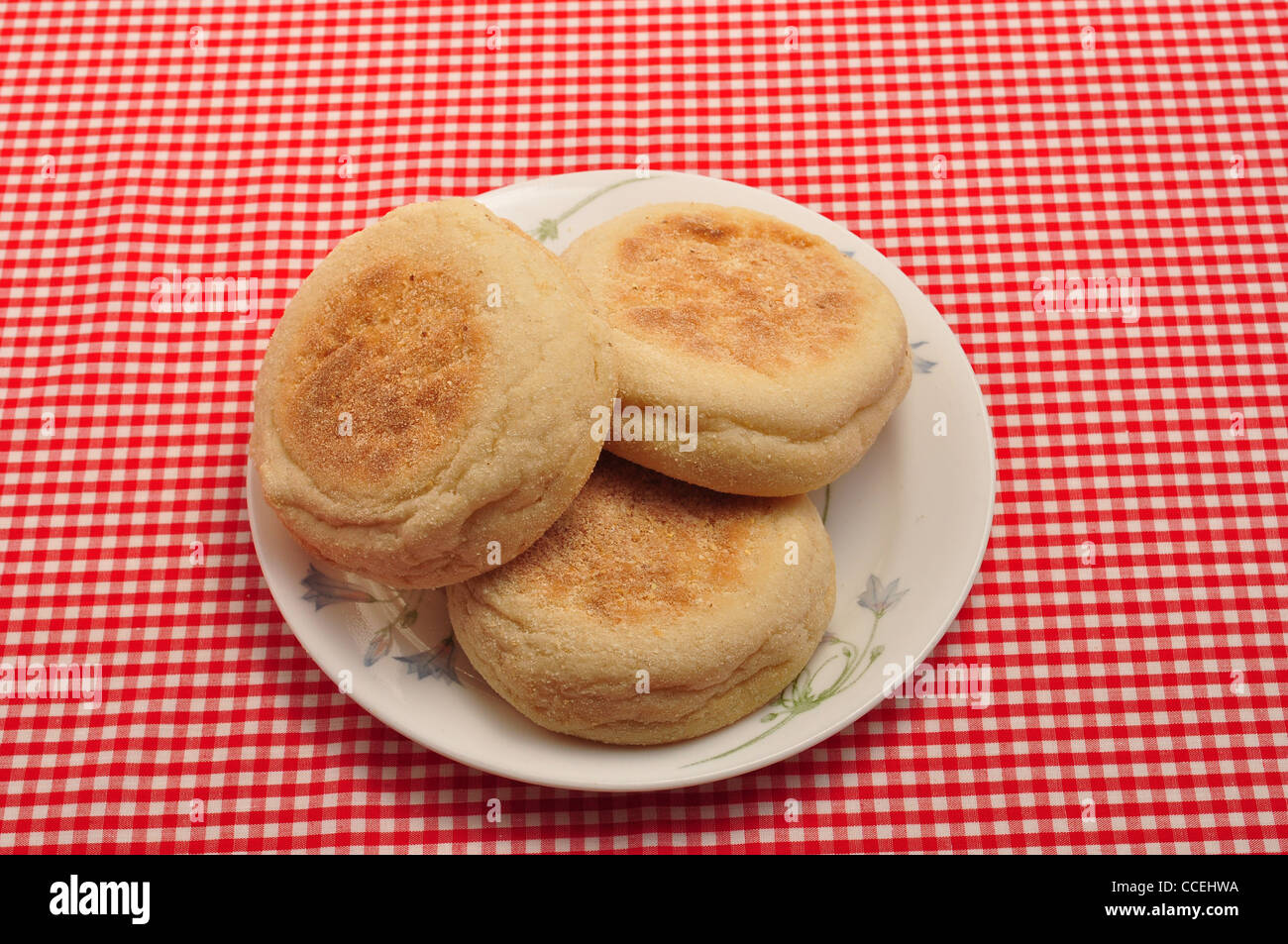 https://c8.alamy.com/comp/CCEHWA/english-muffins-on-a-saucer-on-a-red-and-white-check-background-CCEHWA.jpg