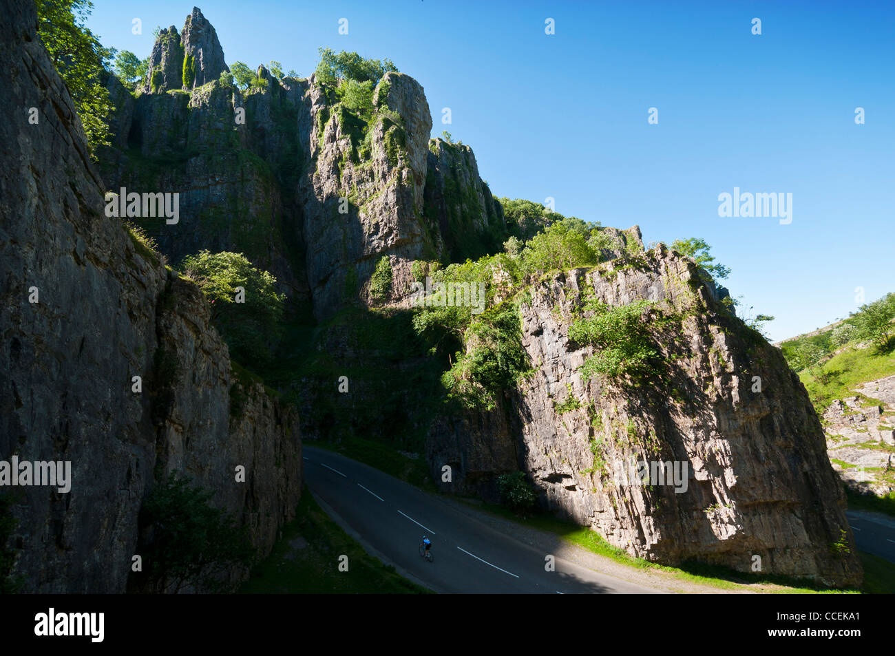 A lone cyclists climbing the road through dramatic Cheddar gorge on a fine sunny summer morning Stock Photo