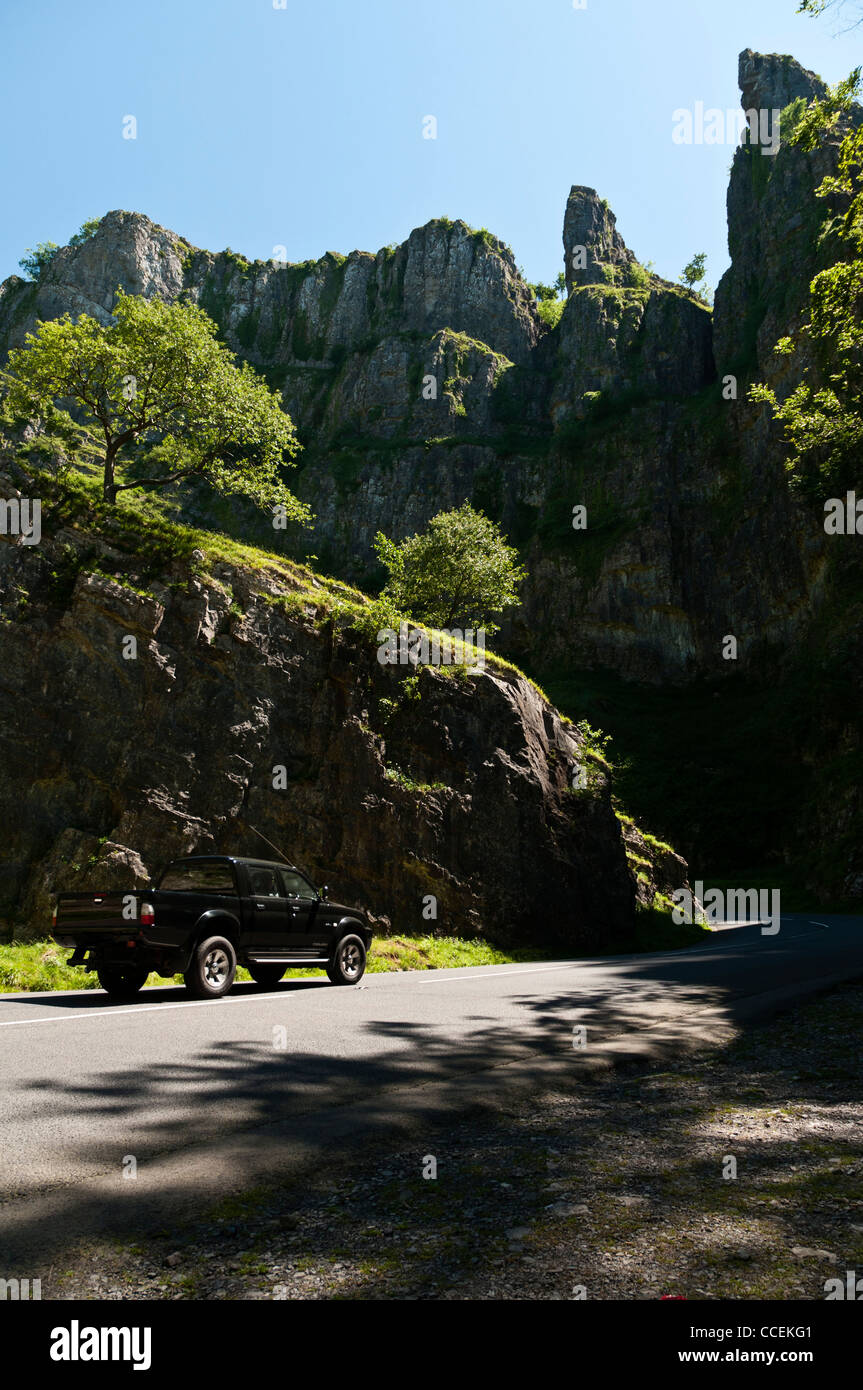 An pickup truck driving though Cheddar Gorge on a very sunny early summer day. Stock Photo