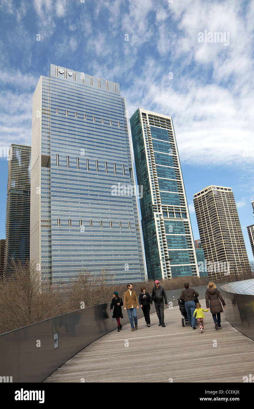 People walk on the BP Bridge, skyscrapers in the background. Chicago, Illinois, United States Stock Photo