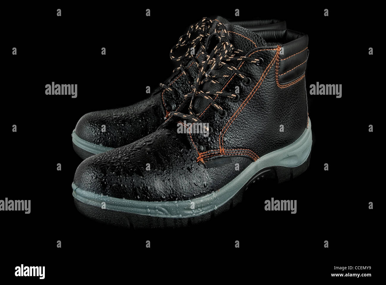 moist modern working boots isolated on a black background Stock Photo ...