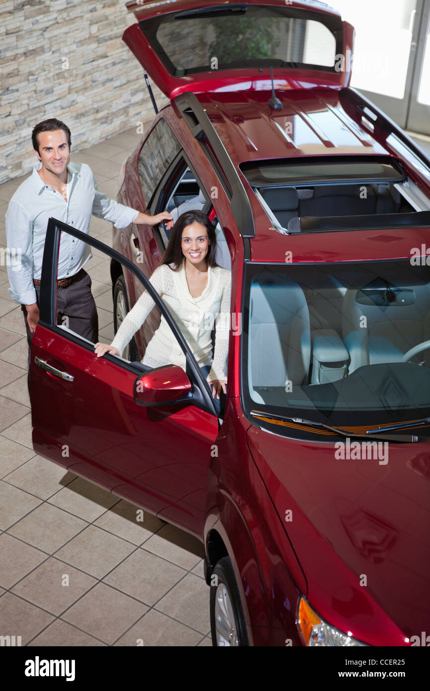 Happy couple in luxury car show room Stock Photo