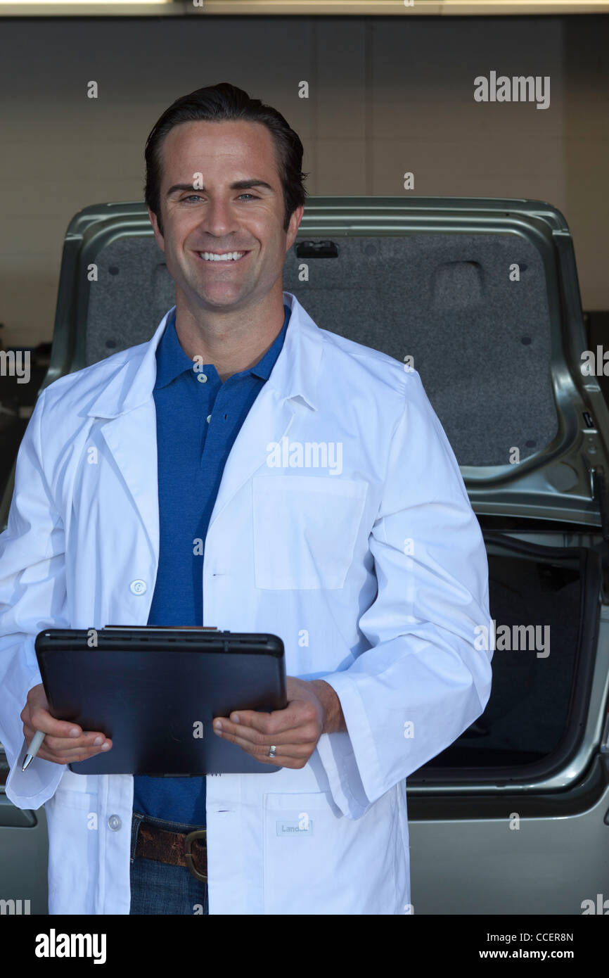 Portrait of smiling car salesman holding clipboard Stock Photo