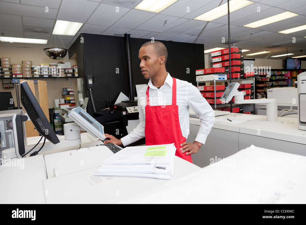 Manual worker looking at cash register machine Stock Photo