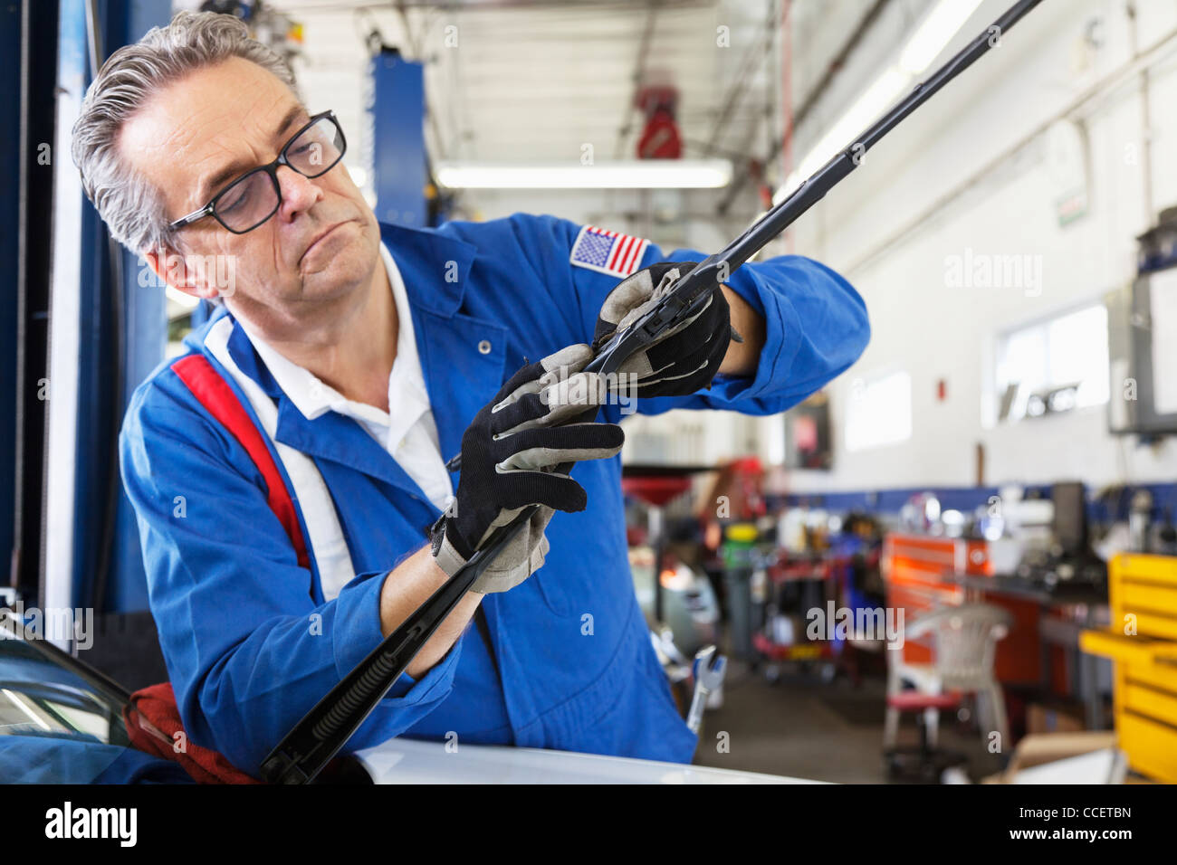 Mechanic working on windshield wipers of car Stock Photo