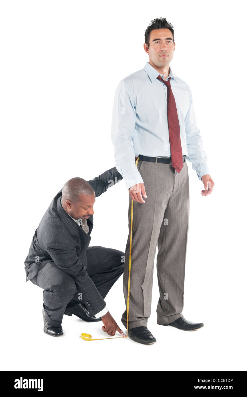 Tailor taking measure leg of customer Stock Photo